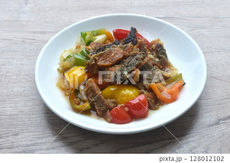deep fried slice mango fish with bell pepper and onion in black pepper sauce on plate  128012102