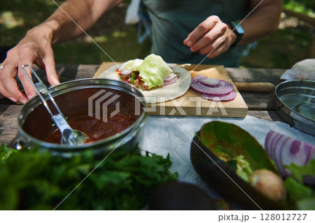 Close-Up of Outdoor Picnic Scene with Fresh Wrap Preparation Close-Up of Outdoor Picnic Scene with Fresh Wrap Preparation 128012727