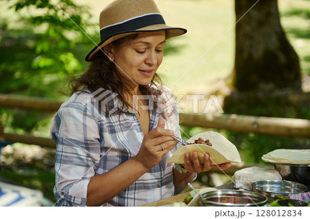 Woman Enjoying A Freshly Prepared Meal Outdoors With Relaxing Picnic Vibes 128012834