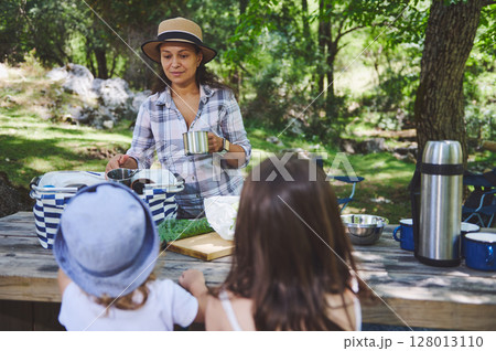 Family Enjoying Outdoor Picnic Surrounded by Nature 128013110