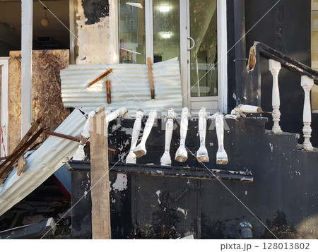 Storefront in a city shows extensive damage after a crash or tornado. 128013802