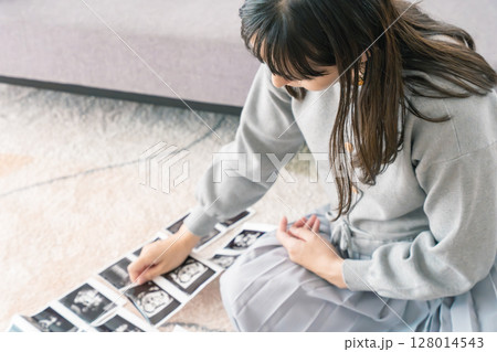 エコー写真を見て赤ちゃんが生まれてくるのを楽しみにしている妊婦 128014543