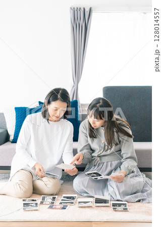 エコー写真を見ながら、赤ちゃんが生まれてくるのが待ち遠しい母と娘 128014557