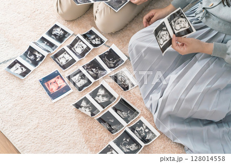 エコー写真を見ながら、赤ちゃんが生まれてくるのが待ち遠しい母と娘 128014558