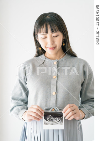 エコー写真を持った妊婦のポートレイト エコー写真を持った妊婦のポートレイト 128014598