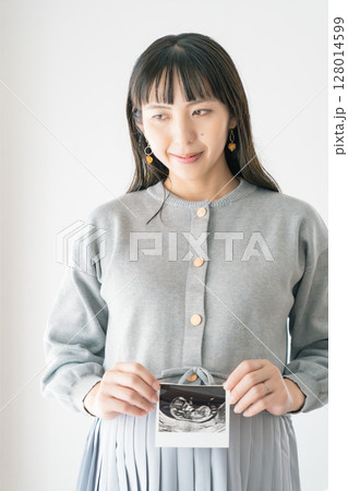 エコー写真を持った妊婦のポートレイト 128014599