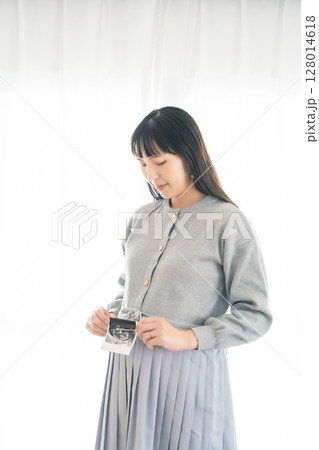 エコー写真を持った妊婦のポートレイト 128014618