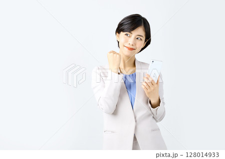 白バックの前でスマホを操作するビジネスウーマン 白バックの前でスマホを操作するビジネスウーマン 128014933
