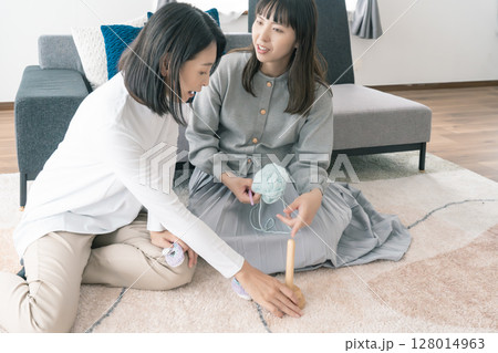ベビーシューズを編む母と娘 128014963