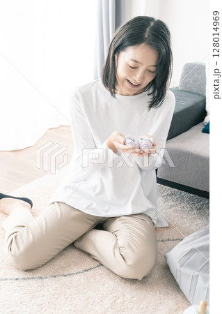 ベビーシューズを見て初孫を想像している母 ベビーシューズを見て初孫を想像している母 128014969