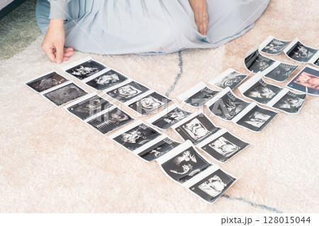 エコー写真を見て赤ちゃんが生まれてくるのを楽しみにしている妊婦 128015044