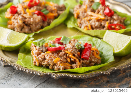 Asian Lettuce Wraps are filled with saucy, gingery beef and vegetables close-up on the plate. Horizontal Asian Lettuce Wraps are filled with saucy, gingery beef and vegetables close-up on the plate. Horizontal 128015463
