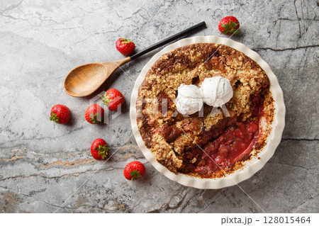 Homemade cocoa strawberry cobbler with vanilla ice cream close-up in baking dish. horizontal top view 128015464