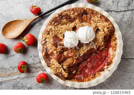 Summer dessert cocoa strawberry cobbler with vanilla ice cream close-up in baking dish. horizontal top view 128015465