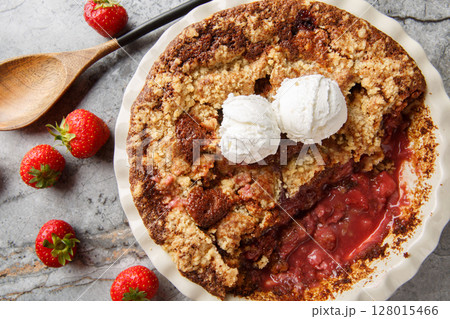 Strawberry cobbler pie with ice cream close-up in baking dish. Horizontal top view Strawberry cobbler pie with ice cream close-up in baking dish. Horizontal top view 128015466