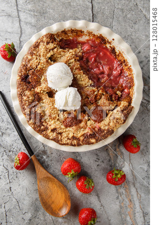 Chocolate strawberry cobbler with vanilla ice cream close-up in baking dish. Vertical top view Chocolate strawberry cobbler with vanilla ice cream close-up in baking dish. Vertical top view 128015468