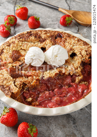 Chocolate strawberry cobbler with vanilla ice cream close-up in baking dish. Vertical 128015474
