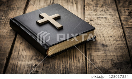 A wooden background featuring a cross resting on an open book, symbolizing faith and reflection 128017824