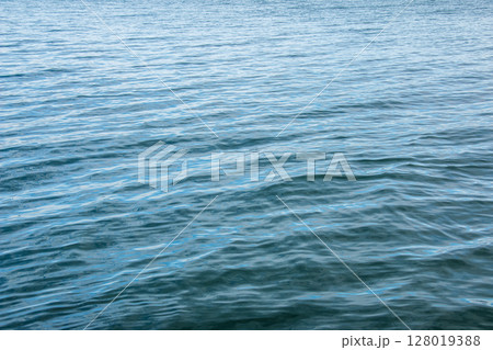 Water background of lake Traunsee in the Alps. The colorful texture of reflections of a clear mountain lake. Texture of water with reflections. 128019388