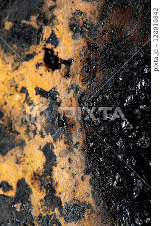 Close up of heavy black rust on a brass base of a kitchen sauce pan abstract background 128019842