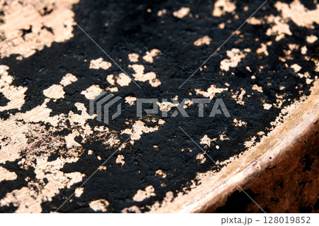 Close up of heavy black rust on a brass base of a kitchen sauce pan abstract background 128019852