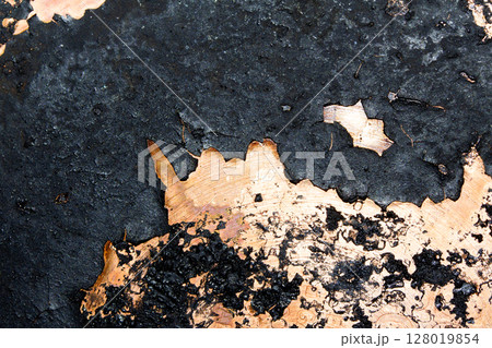 Close up of heavy black rust on a brass base of a kitchen sauce pan abstract background Close up of heavy black rust on a brass base of a kitchen sauce pan abstract background 128019854