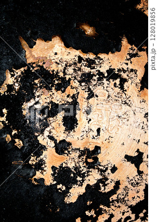 Close up of heavy black rust on a brass base of a kitchen sauce pan abstract background 128019856