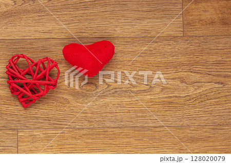 Two Red Heart-Shaped Decorations on Rustic Wooden Surface 128020079