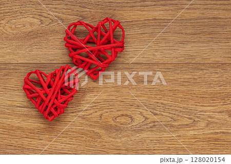 Two Red Heart-Shaped Decorations on Rustic Wooden Surface 128020154