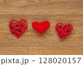 Two Red Heart-Shaped Decorations on Rustic Wooden Surface 128020157
