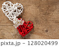 Romantic White and Red Woven Hearts with Flowers on Rustic Wooden Background 128020499