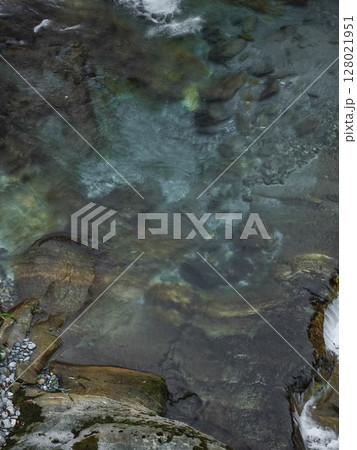 Water cascading over polished rocks in aosta valley, revealing autumnal tranquility with crystalline textures and soft light pontboset 128021951