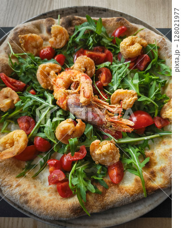 Crispy pizza topping featuring fresh arugula, succulent shrimp, vibrant cherry tomatoes on rustic italian style crust in aosta region Crispy pizza topping featuring fresh arugula, succulent shrimp, vibrant cherry tomatoes on rustic italian style crust in aosta region 128021977