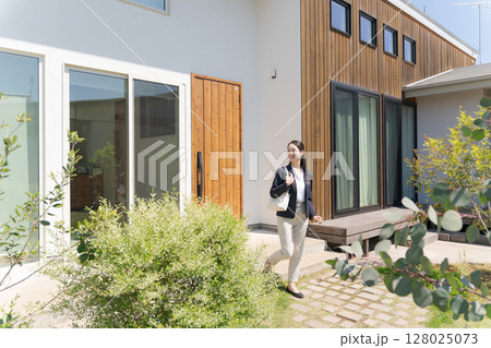 自宅の玄関を出るスーツの女性 自宅の玄関を出るスーツの女性 128025073