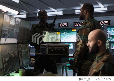 Air defense specialist using radar on laptop to detect missile attacks and conducting space surveillance and satellite tracking. Army expert using military software on notebook preventing rockets 128026589