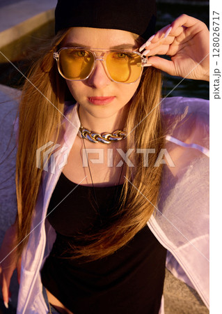 Styled moment. Youthful dancer posing confidently in urban setting with trendy outfit and accessories 128026717