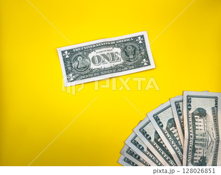 1 dollar and stack of dollars, trade war tariffs, on yellow background, centered on image, top view 128026851