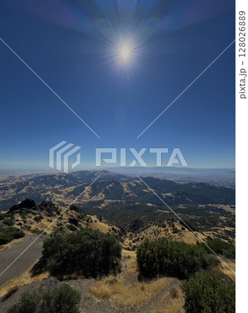 View of the foothills of Mount Diablo from the top of the mountain itself, in the summer with bright sun and blue sky in the background 128026889