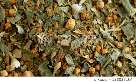 An upclose shot of dried peppermint leaves surrounded by hints of lemon verbena and chamomile forming a refreshing and invigorating herbal infusion mix An upclose shot of dried peppermint leaves surrounded by hints of lemon verbena and chamomile forming a refreshing and invigorating herbal infusion mix 128027164