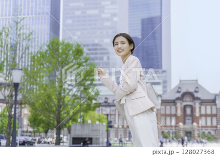 東京駅の前に立つ若いビジネスウーマン 128027368