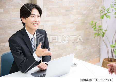 お客様に説明する若手の営業マンなどのイメージ 説明やプレゼンの横顔 お客様に説明する若手の営業マンなどのイメージ 説明やプレゼンの横顔 128027541