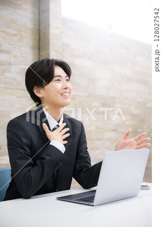 お客様に説明する若手の営業マンなどのイメージ　説明やプレゼンの横顔 128027542