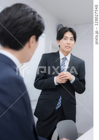 営業や提案で痛いところをつかれて気まずいビジネスマン男性　これって失注かな…？の困った表情 128027548