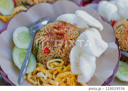 Authentic Indonesian Nasi Goreng served with fried egg, cucumber, and crackers Authentic Indonesian Nasi Goreng served with fried egg, cucumber, and crackers 128029556