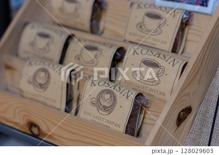 Stack of Kosasin Instant Coffee Sachets Displayed in a Wooden Rack at Mataram, Indonesia on November 10, 2024 Stack of Kosasin Instant Coffee Sachets Displayed in a Wooden Rack at Mataram, Indonesia on November 10, 2024 128029603