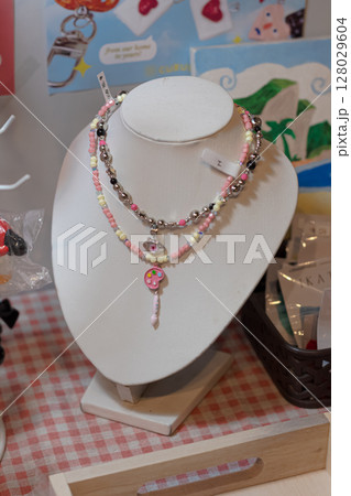 Handmade colorful beaded necklaces with whimsical pendants displayed on a jewelry stand. at Mataram, Indonesia on November 10, 2024 Handmade colorful beaded necklaces with whimsical pendants displayed on a jewelry stand. at Mataram, Indonesia on November 10, 2024 128029604