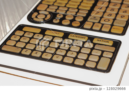 Close-up view of vintage electronic device control panel with many buttons 128029666