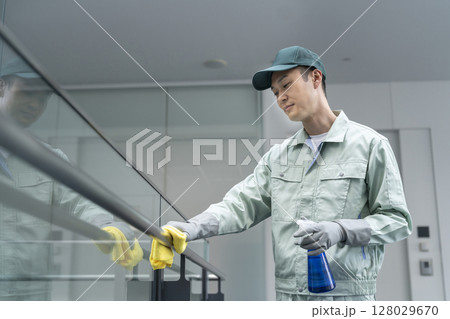 拭き掃除をするミドルの男性クリーニングスタッフ　ビルクリーニングイメージ 128029670