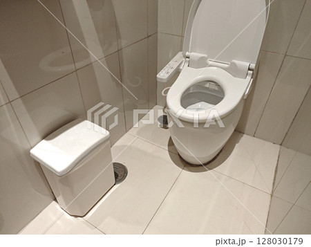 Modern bathroom interior with clean toilet and waste bin 128030179