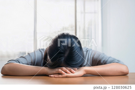 机に伏せる女性 机に伏せる女性 128030625